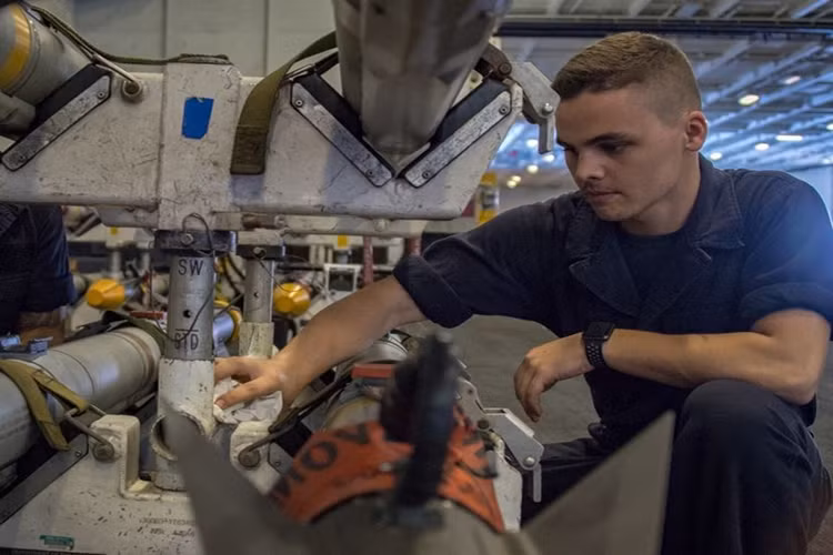 Chuyên gia hàng không Drew Harrington đang lau chùi thiết bị trong hangar tàu sân bay CVN 70, ngày 20/2/2018. Nguồn ảnh: US Navy.