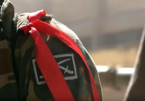 Một binh sỹ Syria đeo băng ruy băng đỏ ra chiến tuyến.