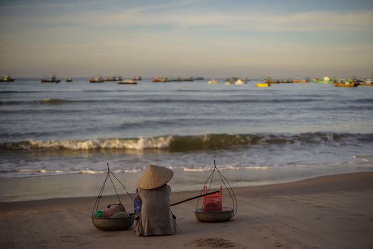 Một ngư dân đợi tàu về tại bờ biển làng Kê Gà, Bình Thuận. Ảnh: Sputnik.