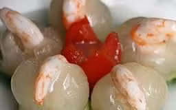 Với món này những con tôm tươi được hấp chín bọc vỏ sạch sẽ được nhồi vào trong quả nhãn lồn-g, sau đó rưới thêm nước sốt và thưởng thức.