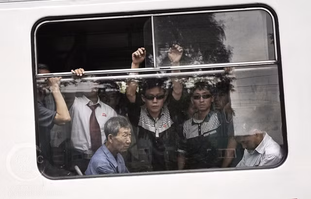 Cảnh người dân Triều Tiên đứng chen nhau trong xe buýt vào giờ cao điểm buổi sáng ở Bình Nhưỡng. Ở Triều Tiên phương tiện công cộng vẫn đóng vai trò chủ yếu hơn là các phương tiện cá nhân. (Nguồn ảnh: Ifeng)
