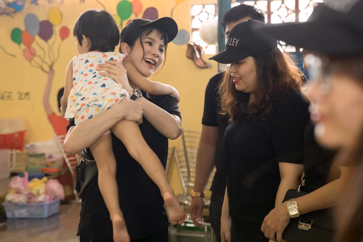 Cô vui vẻ bế các em nhỏ trong cơ sở từ thiện tại chùa Kỳ Quang.