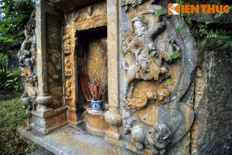 Chính giữa phiến đá là một bàn thờ và bia đá được chạm chìm vào bên trong. Hai bên có hai cột đá, chân cột tạo hình quả anh túc, giống như hai cột đá phía trước gian nhà trung tâm của dinh thự Vua Mèo.