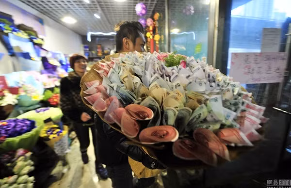 Thời gian gần đây, đặc biệt là trong dịp Valentine vừa qua, ở Trung Quốc rộ lên "mốt" tặng hoa cuốn tiền đầy vẻ "sang chảnh. Trong ngày lễ tình nhân, những món quà quen thuộc như gấu bông, chocolate hay hoa bình thường đều bị quên lãng... thay vào đó là sự lên ngôi của những bó "hoa" sực mùi tiền giấy.