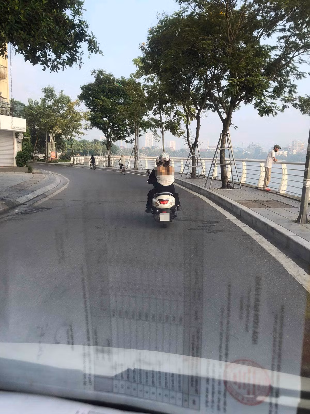 Mạng xã hội vừa lan truyền hình ảnh một cô gái trẻ ngồi sau xe máy với phong cách ăn mặc phản cảm đi qua khu vực Hồ Tây lộng gió. Hình ảnh ghi lại cô gái này mặc chiếc áo trắng mỏng dính bên ngoài, chiếc áo này tuột hẳn đến ngang hông, để lộ phần lưng hớ hênh và áo ngực bên trong rất phản cảm.