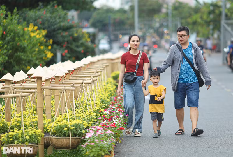 Hai bên lối vào và dọc tuyến đường trong công viên được trang trí các gánh hoa, nón lá... Nhiều gia đình tranh thủ thời gian đưa con nhỏ tới dạo chơi, thưởng thức không gian Tết sớm.