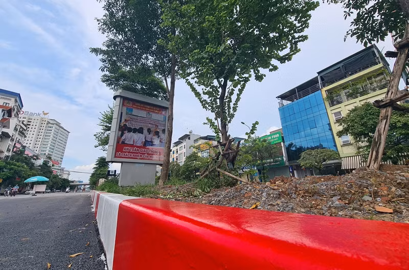 Một phần đường đã hoàn thiện, lớp sơn đỏ trắng được phủ mới lên dải phân cách làm bằng những khối bê tông đúc sẵn.