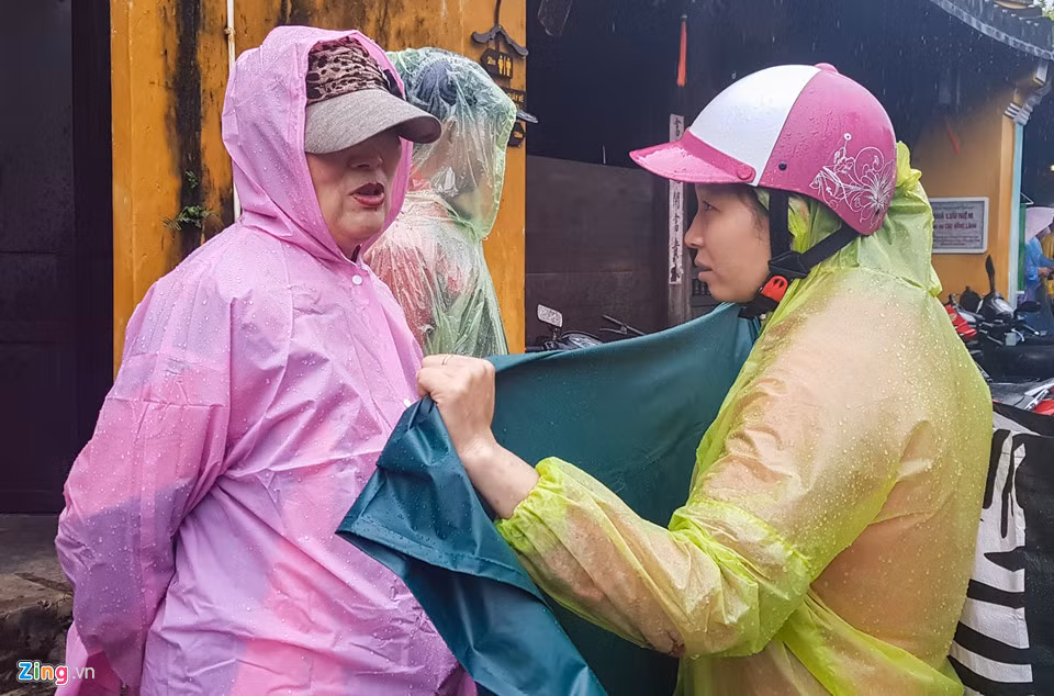 Người Hội An xem lũ về là cơ hội kiếm tiền. Trong hình, một người Hội An chèo thuyền đi bán áo mưa.