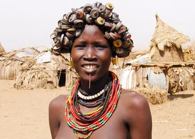 7. Bộ lạc Daasanach, Ethiopia: Thung lũng Omo ở Ethiopia là một trong những khu vực đông dân cư nhất của người thuộc bộ lạc Daasanach. Người dân nơi đây có sở thích tái chế rác thải và biến chúng thành đồ trang sức. Phụ nữ đeo những chiếc vòng cổ sặc sỡ hay mái tóc gắn đầy nắp chai sẽ là hình ảnh thường thấy khi bạn ghé thăm Daasanach. Ảnh: BS.