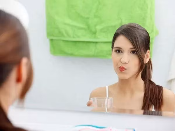 Tráng miệng bằng dầu dừa: Đây là phương pháp dùng dầu dừa tráng sạch miệng và làm trắng răng một cách tự nhiên. Lấy một nửa thìa dầu mè, dầu dừa và vài giọt dầu cây trà. Xoa trong miệng khoảng 10 phút rồi nhổ đi. Nên làm điều này thường xuyên để cải thiện tình trạng răng miệng của bạn. Ảnh: Boldsky.