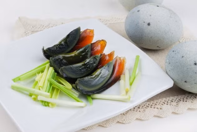 4. Trứng thế kỷ của Trung Quốc: Trứng thế kỷ có mùi ammoniac đậm đặc nên có tên gọi khác là “trứng nước tiểu ngựa”. Để tạo ra món ăn này, người ta phải pha một thùng nước gồm trà đen đậm đặc, vôi, muối và tro gỗ để nguội qua đêm. Ngày hôm sau, trứng gà, trứng vịt hoặc trứng cút sẽ được cho vào ngâm trong hỗn hợp khoảng 7 tuần đến 5 tháng. Đến khi ăn, trứng sẽ có màu xanh đen và bốc mùi khai. Ảnh: Listverse.