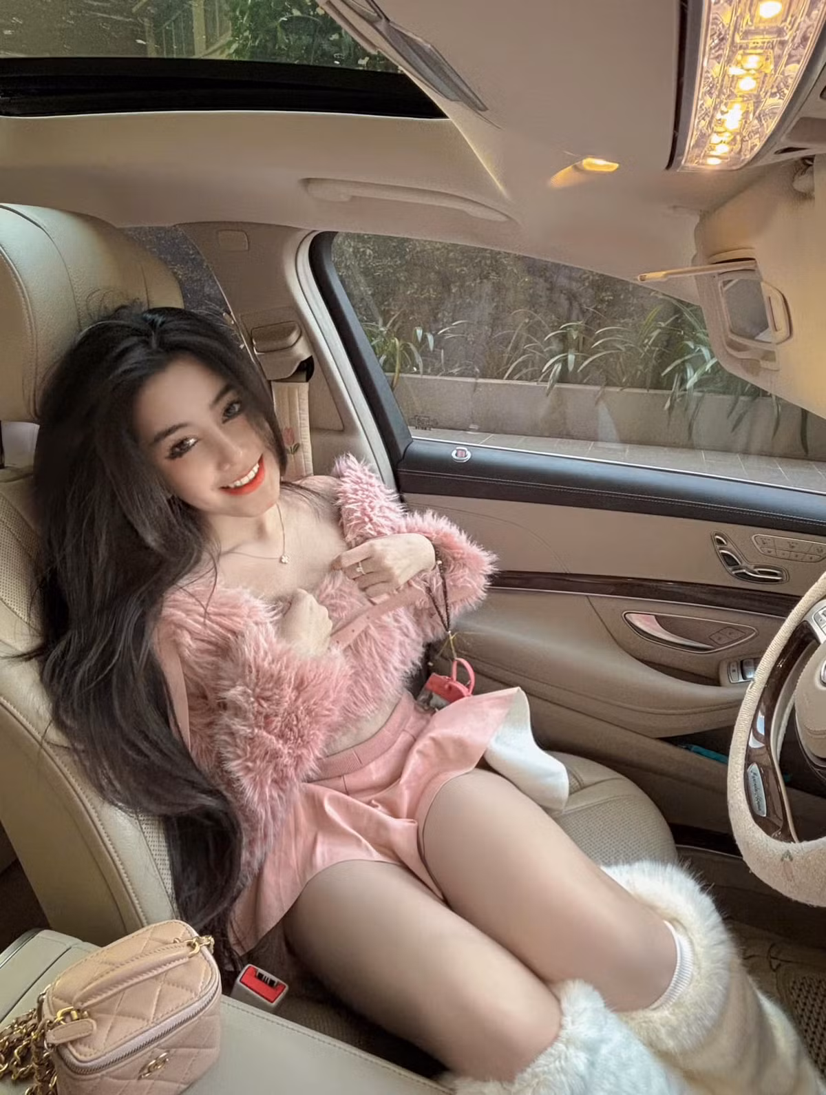 Cô diện trang phục màu hồng, chân váy ngắn cũn tạo dáng, khoe vòng eo con kiến.
