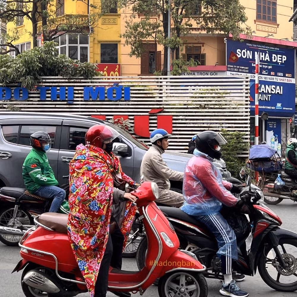 Người điều khiển xe máy này trùm chăn đi đường đã thu hút sự chú ý của người đi đường. Ảnh: #hadongban