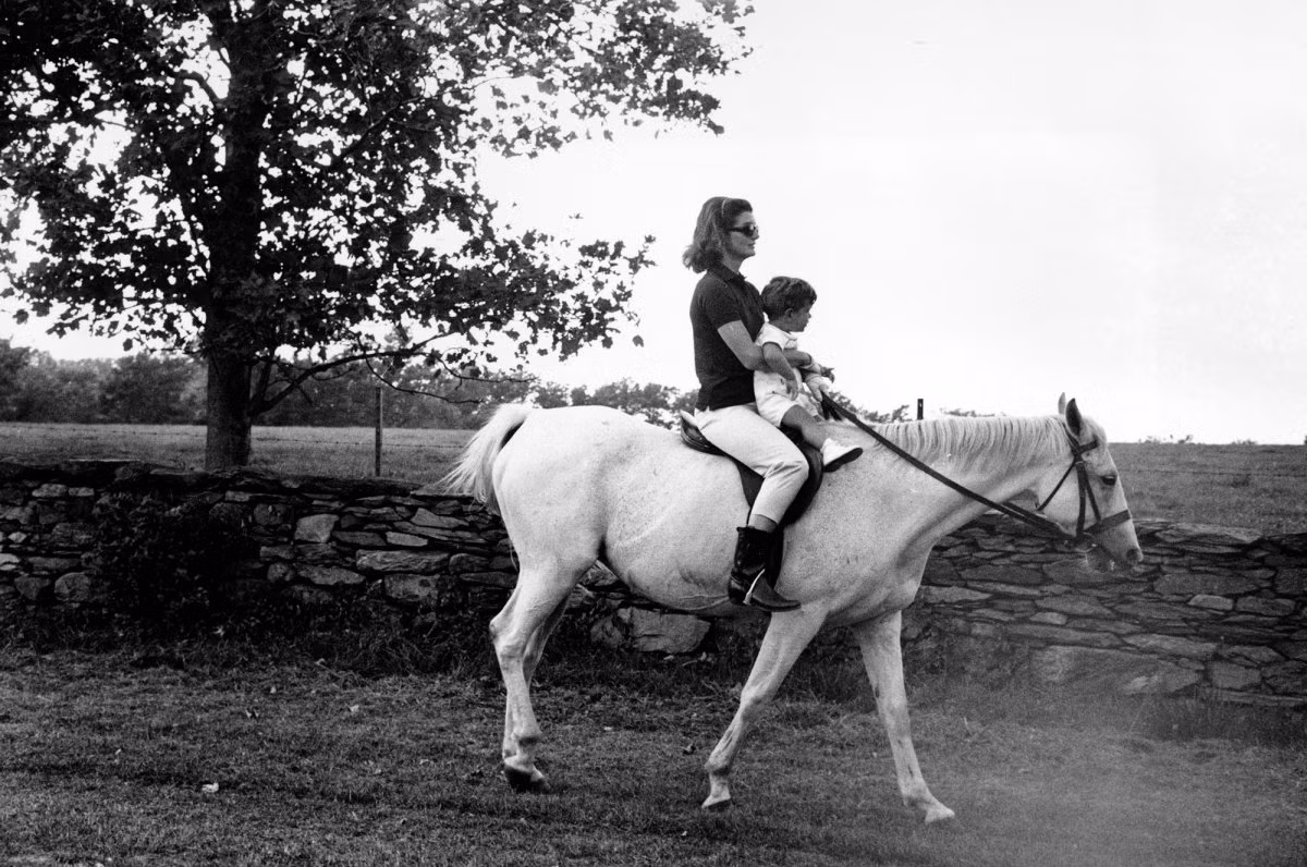 Đệ nhất phu nhân Jacqueline Kennedy cùng con trai John F. Kennedy Jr thong dong cưỡi ngựa trong chuyến đi nghỉ ở trang trại Hammersmith năm 1962.