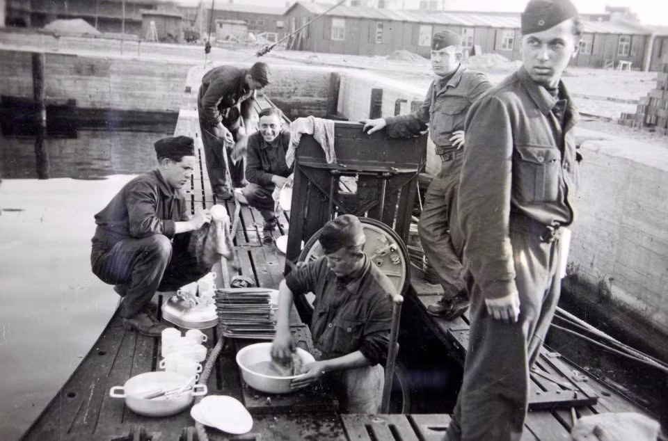 Những thành viên thủy thủ đoàn làm việc trên tàu ngầm U-boat dọn rửa ở bến tàu.