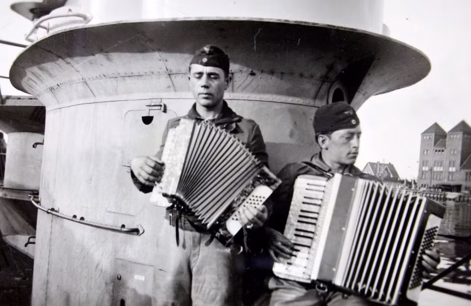 Hai thành viên thủy thủ đoàn chơi đàn accordion trong lúc rảnh rỗi.