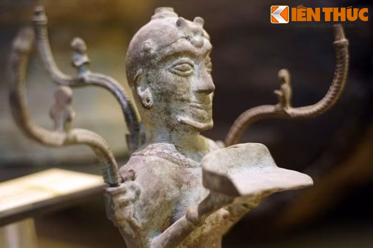 Theo nhà nghiên cứu O.Jane, bức tượng thể hiện hình ảnh một vị thần. Có ý kiến cho rằng cây đèn thể hiện ảnh hưởng văn hóa Hán thời đầu Bắc thuộc và người đàn ông quỳ là một tù binh Hung Nô bị bắt và trở thành người hầu bê đèn.