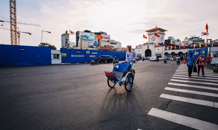 Bác tài xích lô thong dong trước chợ Bến Thành.