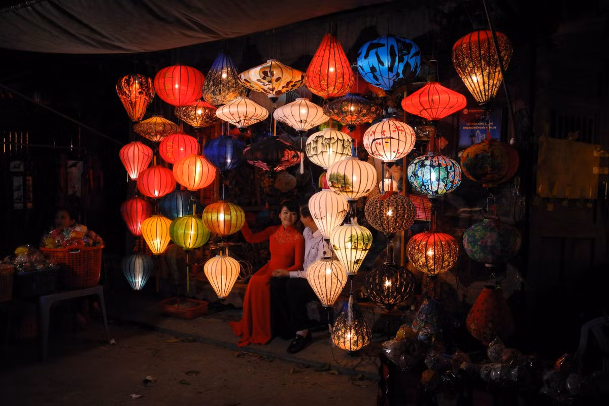 Đôi bạn trẻ chụp ảnh bên đền lồng treo bên ngoài một cửa hàng bán đồ lưu niệm ở phổ cổ Hội An, tỉnh Quảng Nam. Ảnh USN