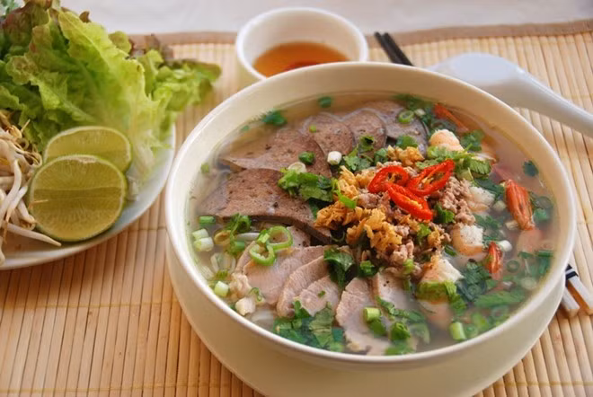 Hủ tiếu: Một trong những món ăn ngon được nhiều người ưa chuộng ở miền Tây là hủ tiếu. Nước lèo hủ tíu trong veo, thơm lừng mùi mực nướng, mùi tôm khô, mùi hành phi,… Xương ống, giò heo và sườn non chặt miếng được hầm mềm rượi. Còn sợi hủ tiếu thì nhỏ rứt như sợi bún có độ dai vừa phải, không quá dai mà cũng không quá bở.