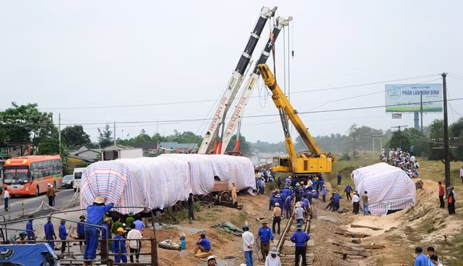 16h30 ngày 11/3, tuyến đường sắt sắp được thông trở lại, các toa tàu trật bánh được dựng dậy, phủ bạt che kín. 