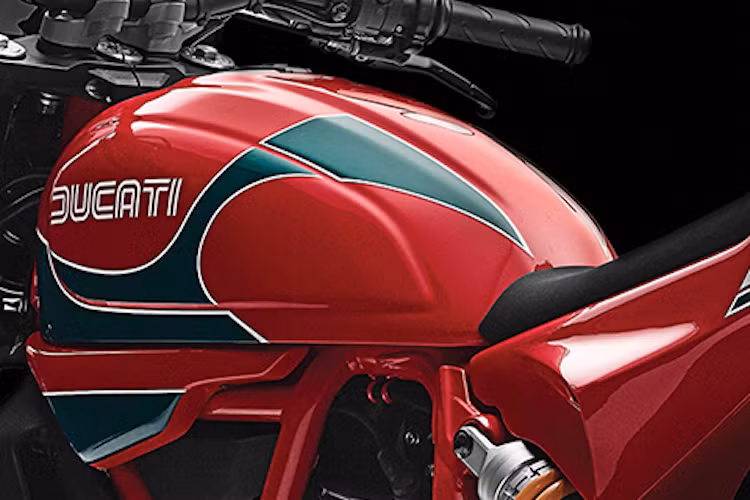 Bình xăng nguyên bản của Scrambler được giữ lại, nhưng có tông màu sơn đỏ-xanh lá như chiếc xe đua Ducati 900SS của Mike Hailwood.
