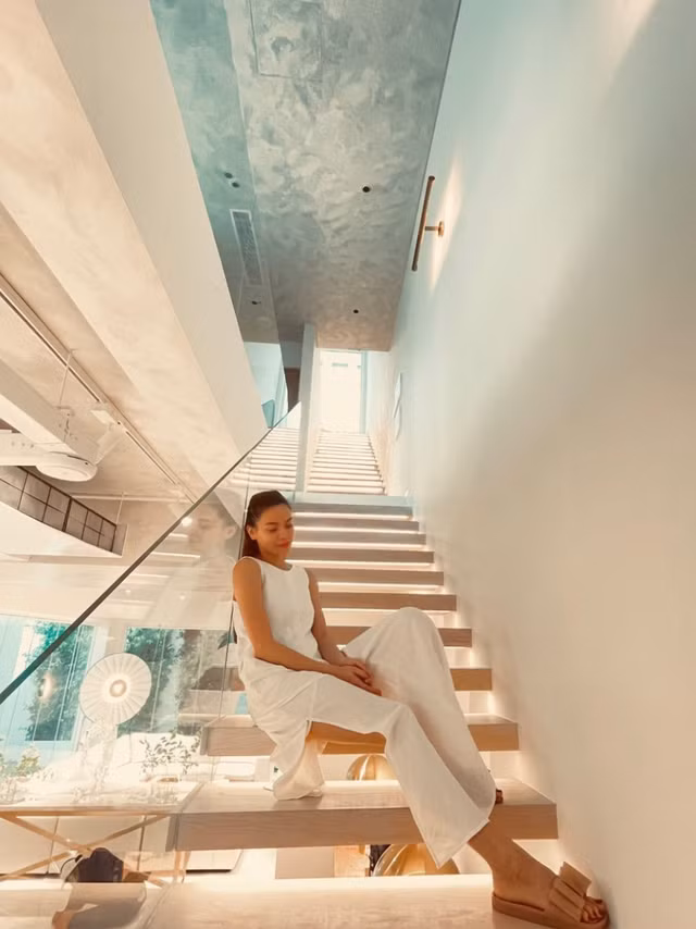 Cầu thang gỗ trong nhà thiết kế mở, bao phủ bởi lớp kính dày. Ảnh: FBNV