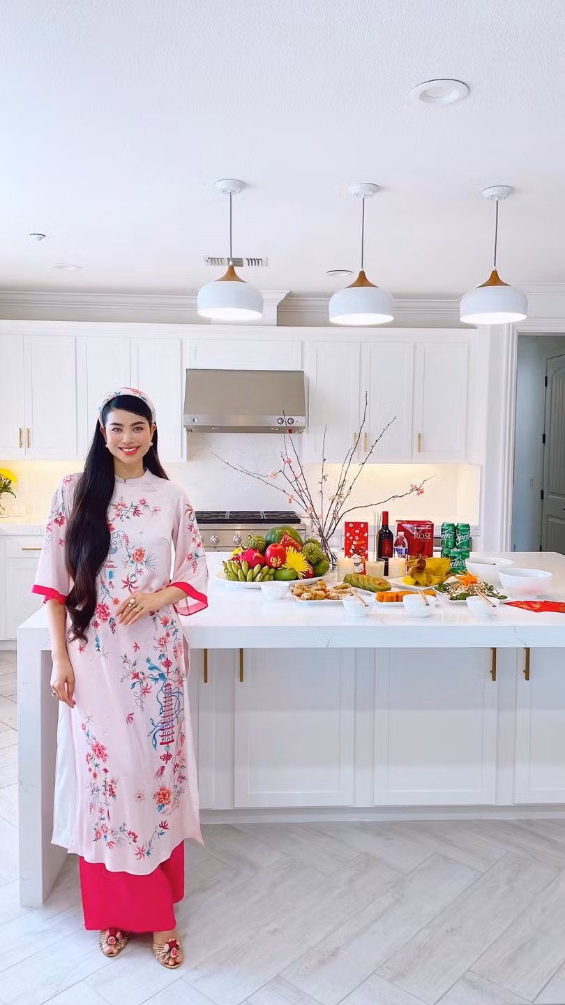 Phòng bếp có gam màu trắng chủ đạo, được tô điểm bằng hoa tươi.