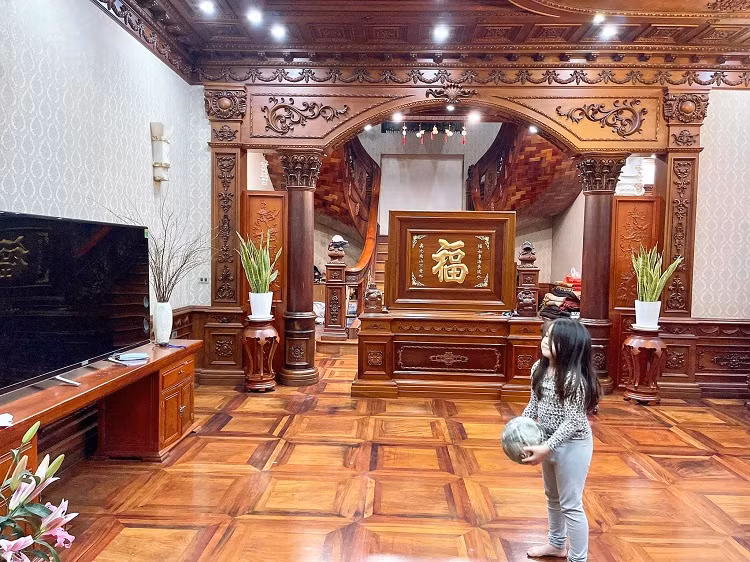 Phòng khách rộng rãi với sàn và trần được ốp gỗ gõ đỏ. Ảnh: Dân Việt