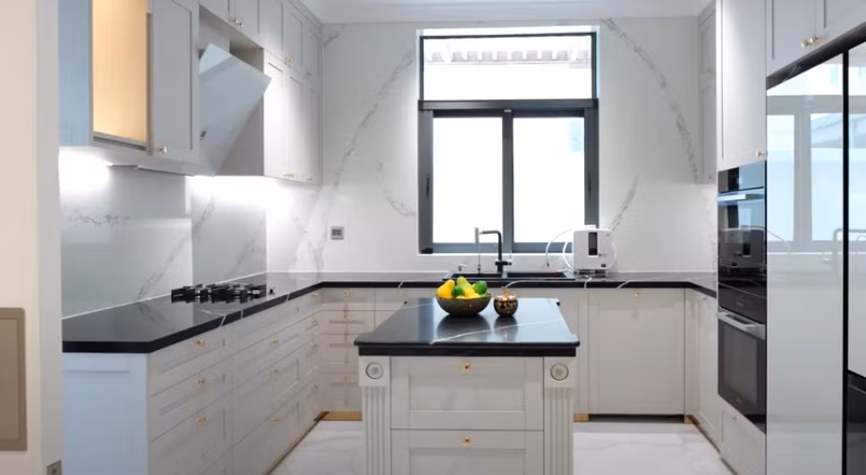 Nhà bếp sử dụng gam màu trắng chủ đạo với hệ thống tủ cả sát trần đến dưới sàn.