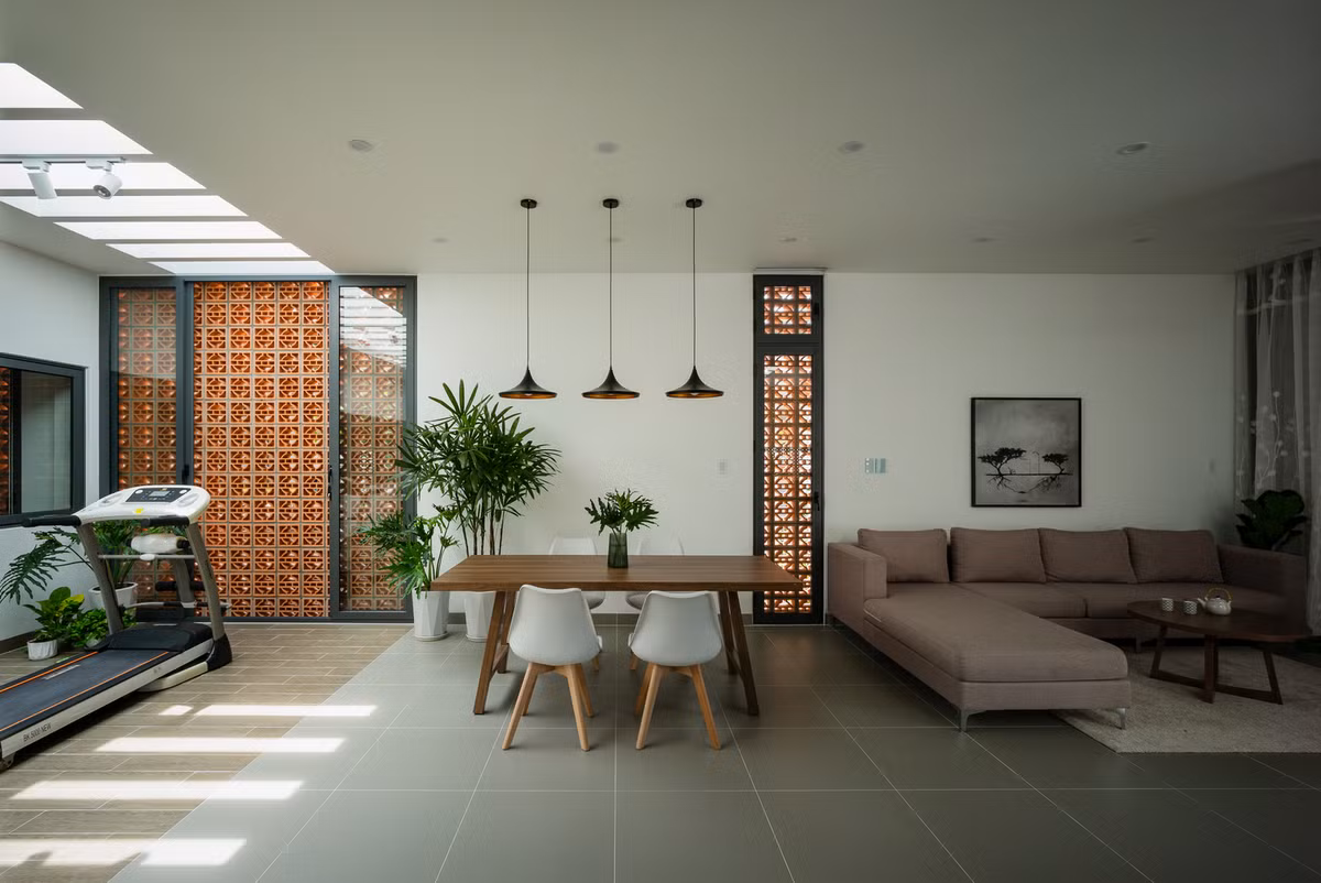 Gạch thông gió đất nung, màu gỗ trầm trên nền sơn trắng kết hợp mảng xanh tạo nên nét hiện đại pha chút mộc mạc hòa mình vào thiên nhiên.