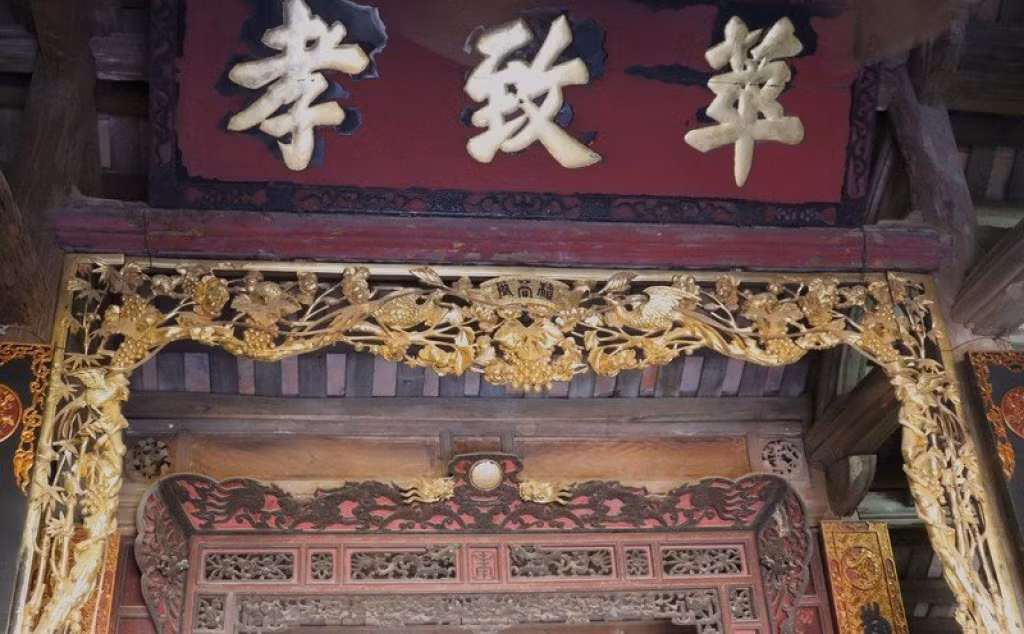 Bức thiều châu cùng với ba chữ “Hiếu - Trí - Hoa” sơn son thiếp vàng được gia đình ông Hùng coi như bảo vật. Ảnh: VOV