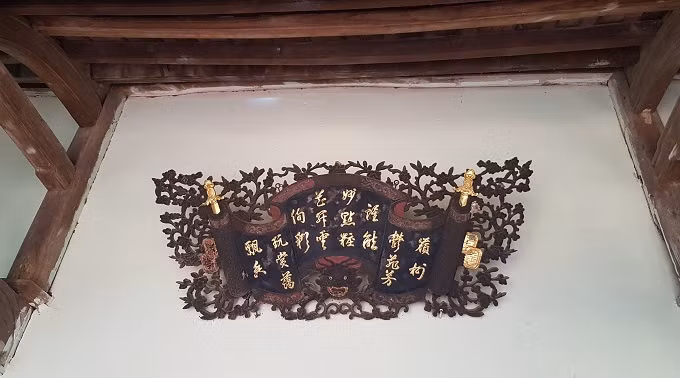Phía ngoài cửa chính là bức cuốn thư cổ. Một số họa tiết trên bức cuốn thư cũng được dát vàng. Ảnh: Vietnamnet