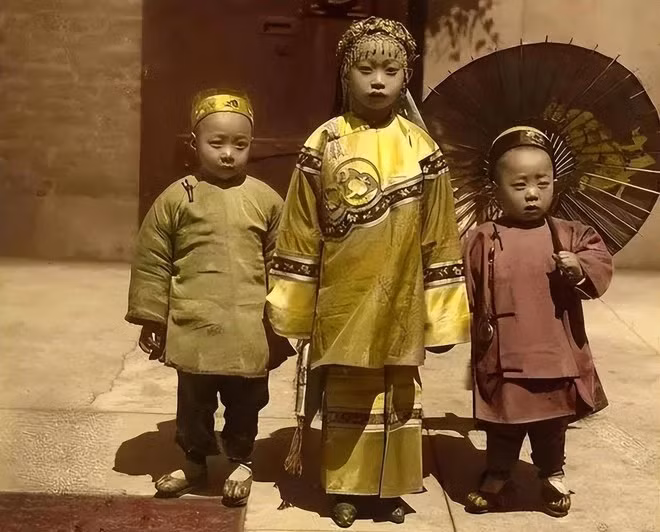 Ba đứa trẻ xuất thân trong gia đình giàu có mặc những bộ trang phục truyền thống được làm từ chất liệu đắt tiền.