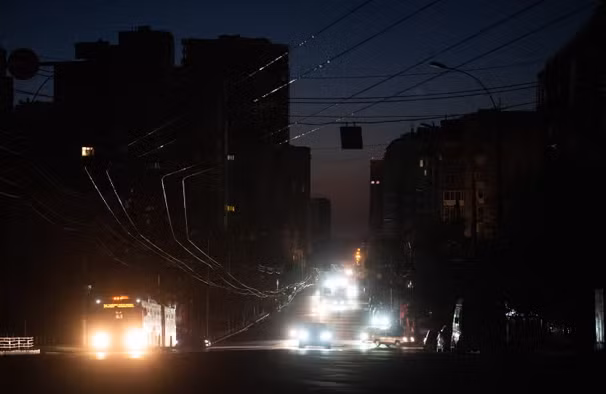 Những chiếc xe đi trên con phố tối tăm ở Kiev.