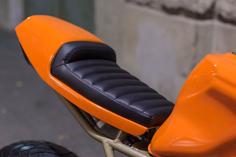 Toàn bộ thân xe được sơn màu cam, bình xăng được gò lại cho phù hợp với tổng thể chiếc xe. Yên xe được làm mới thủ công màu đen dạng da mềm. Ốp đuôi được thiết kế liền với bộ phận đế yên.