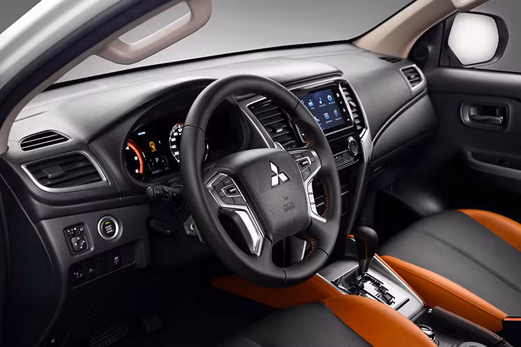 Hài hòa với diện mạo bên ngoài của xe, khoang nội thất của Mitsubishi Triton Athlete được phối hai tông màu cam - đen chủ đạo, tinh tế và cá tính. Những điểm nhấn từ đường chỉ may màu cam ở cần số và ốp cửa, chi tiết cách điệu từ thiết kế thảm lót sàn góp phần tạo ra không gian sống động, mang lại hứng khởi trên mọi hành trình.