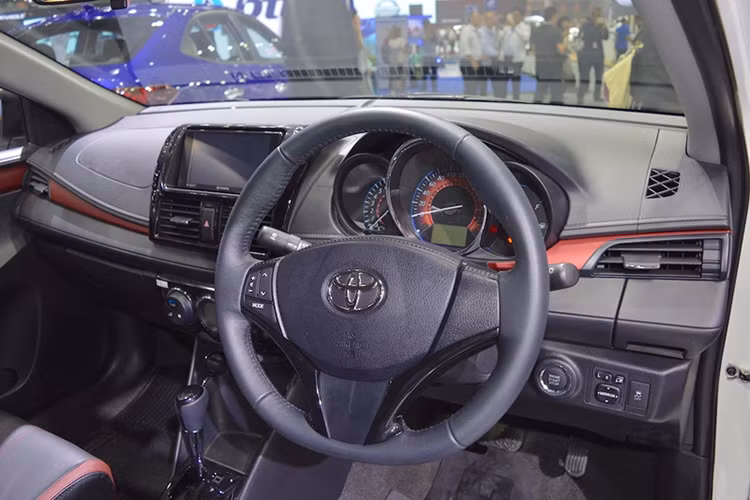 Bên trong nội thất, Toyota Vios 2017 sử dụng tông màu đen chủ đạo bên cạnh những điểm nhấn là viền chỉ đỏ thể thao trên mặt táp lô, cửa và ghế ngồi. Thiết kế vô-lăng dạng 3 chấu thể thao tích hợp phím chức năng, điều hòa hai vùng độc lập,… mang dáng dấp thể thao hơn so với bản cũ.