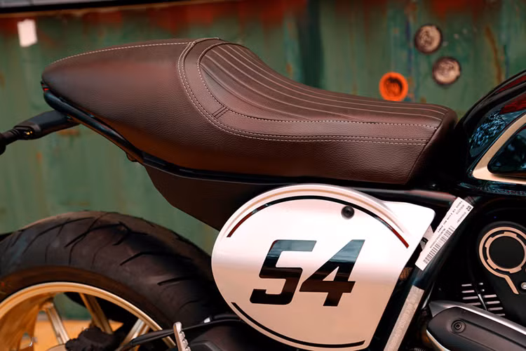 Scrambler Cafe Racer có trọng lượng chỉ 188 kg và chiều cao yên 805 mm được thiết kế đầy cá tính. Ở hai bên thân xe, Scrambler Cafe Racer có 2 miếng nhôm in số 54 theo đúng phong cách những chiếc xe đua cổ điển. Số 54 mang ý nghĩa gợi nhớ về con số gắn liền với tay đua huyền thoại từng "đầu quân" cho Ducati là Bruno Spaggiari. Yên xe được thiết kế cá tính, đậm chất cafe racer.