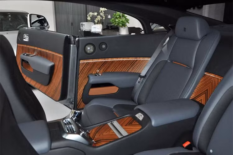 Các chỉ tiết ốp gỗ chủ đạo cũng mang sắc đen. Một vài chi tiết gỗ sáng màu ở bệ trung tâm và cánh cửa tạo nên điểm nhấn. Xe 4 chỗ nhưng chủ yếu phục vụ 2 người phía trước. Hàng ghế sau người lớn vẫn ngồi được nhưng không được thiết kế để phục vụ như một ông chủ.