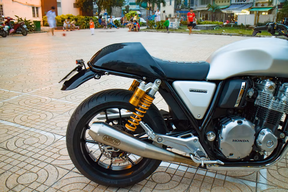 Giảm xóc sau của Honda CB1100 độ khủng này cũng được chủ nhân thay thế bằng giảm xóc bình dầu rời của Ohlins. Hệ thống ống xả nguyên bản nhường chỗ cho cặp ổng xả Arrow cho âm thanh trầm ấm hơn.