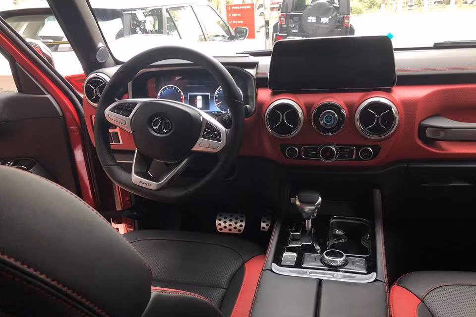 Bước vào bên trong BAIC BJ40L Plus 2018, người lái được chào đón bằng không gian nội thất bọc da, bảng đồng hồ kỹ thuật số, màn hình thông tin giải trí 12,3 inch nằm độc lập, ghế trước chỉnh điện và phanh đỗ xe điện tử. Bên dưới màn hình trung tâm là 2 cửa gió điều hòa hình tròn và nút bấm khởi động máy.