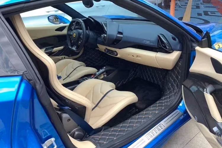 Đối lập với ngoại thất xanh dương, chiếc Ferrari 488 Spider hàng hiếm này sở hữu nội thất màu kem kết hợp cùng nhiều chi tiết được sơn màu đen và phủ carbon ấn tượng. màn hình nằm trên bảng táp-lô, trước tầm mắt của hành khách ngồi trên ghế phụ lái. Lẫy chuyển số cũng được tích hợp trên vô-lăng của mẫu siêu xe đời mới này.