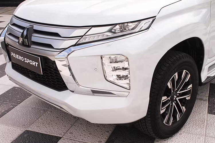 Phần đầu xe nổi bật với mặt ca lăng chữ X, hốc đèn 2 bên khoét sâu, bên trên là đèn chạy LED ban ngày và đèn pha nối liền bằng những thanh mạ bạc. Lưới tản nhiệt phía trước được thiết kế mới với 3 thanh ngang mạ bạc cao cấp làm tăng thêm vẻ mạnh mẽ, thể thao, mở rộng từ nắp ca-pô xuống giúp xe có khả năng làm mát động cơ tốt hơn. Đặc biệt, Mitsubishi Pajero Sport 2020 được trang bị đèn chiếu sáng phía trước công nghệ Bi-LED hiện đại tăng hiệu quả chiếu sáng và thẩm mỹ, đồng thời tích hợp công nghệ đèn chiếu sáng góc hỗ trợ tốt hơn khi vào cua.