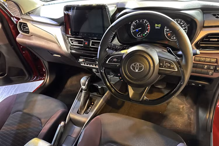 Bên trong Toyota Urban Cruiser Taisor là không gian nội thất phối 2 màu đen - nâu. Thiết kế và trang bị nội thất của mẫu xe này không có gì khác so với Suzuki Fronx, trừ logo của hãng Toyota trên vô lăng.