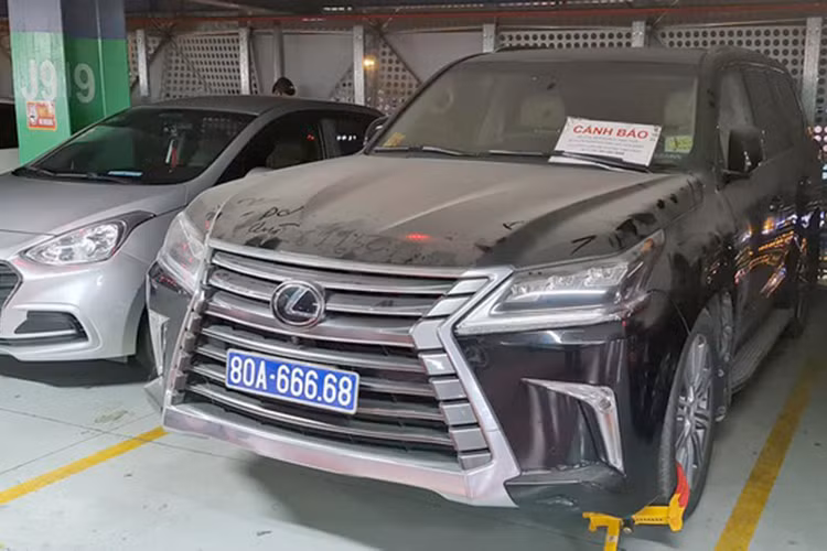 Những ngày qua, mạng xã hội Facebook lan truyền hình ảnh chiếc xe sang Lexus biển xanh 80A-666.68 bị khóa bánh, phủ đầy bụi nằm ở tầng 3 tại bãi giữ xe sân bay Tân Sơn Nhất khiến cộng đồng mạng xôn xao. Ngoài ra, trên kính xe còn được gắn bảng cảnh báo "Xe của quý khách tạm thời bị khóa bánh do đậu sai quy định. (Ảnh N.V.Q.).