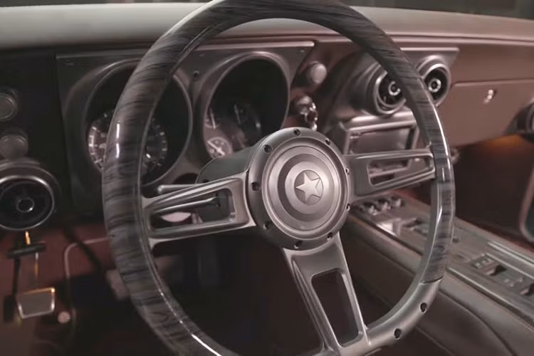 Trên vô lăng của chiếc "xe cơ bắp" Chevrolet Camaro này có biểu tượng hình chiếc khiên đặc trưng của Đội trưởng Mỹ. Trong khi đó, ở bậc cửa xuất hiện ốp ghi dòng chữ "Steve Rogers Special Edition".