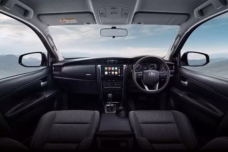 Bên trong xe, Toyota Fortuner Leader S sở hữu nội thất màu đen với mặt táp-lô bọc da, vô lăng bọc urethane, ghế bọc nỉ, ghế trước chỉnh tay, bảng đồng hồ analog tích hợp màn hình đa thông tin 4,2 inch, màn hình cảm ứng trung tâm 8 inch, hỗ trợ kết nối Apple CarPlay/Android Auto, hệ thống âm thanh 6 loa, điều hòa tự động và lọc bụi mịn PM2.5.