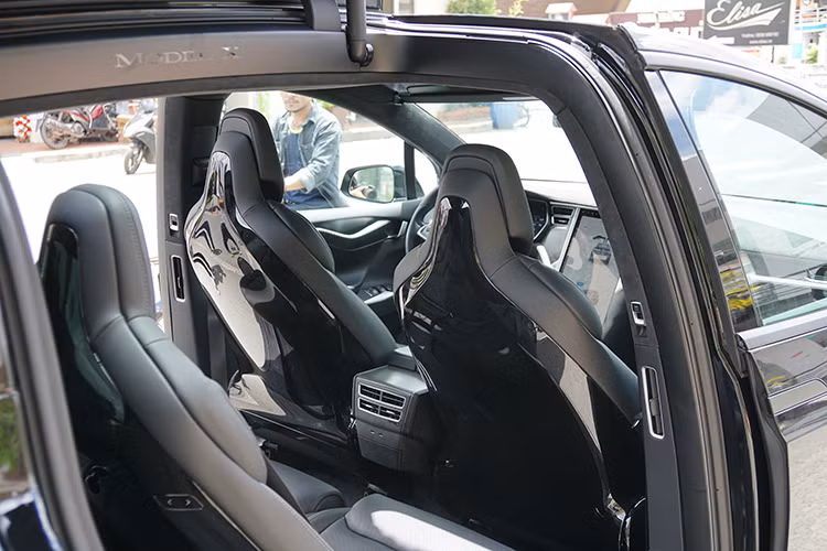 Trên vô-lăng của Tesla Model X P100D tích hợp nút bấm, không có nhiều khác lạ. Cần số gắn sau vô-lăng giống như Mercedes-Benz. Tesla cho biết Model X là chiếc xe đầu tiên có bộ lọc HEPA đặt ở mặt trước của xe, giúp không khí bên trong cabin luôn đảm bảo sạch sẽ, không phụ thuộc chất lượng không khí bên ngoài.