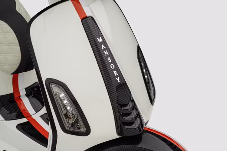 Suốt dọc thân xe Vespa Electtrica độ Mansory nối từ chắn bùn trước, cho tới yếm trước, đầu xe, tới phía phần để chân và đuôi xe là dải màu đỏ trắng đặc trưng của quốc kỳ Monaco.